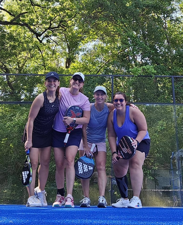 Cuatro personas en cancha de pickleball con paletas