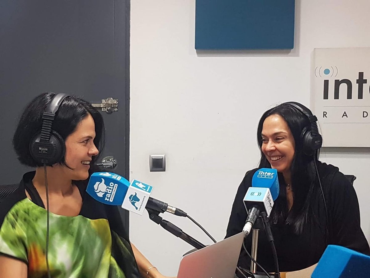 Dos mujeres con auriculares hablando en estudio de radio