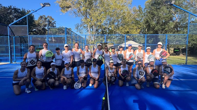 Grupo de personas en cancha de pádel con redes y árboles