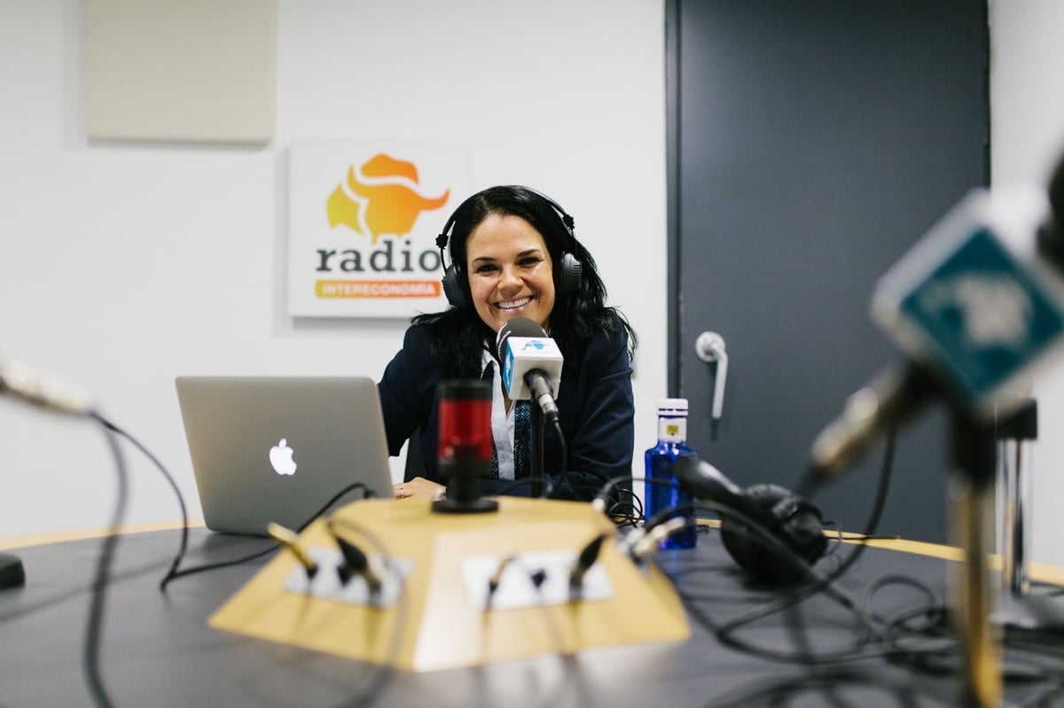 Mone Gil hablando al micrófono en estudio de radio